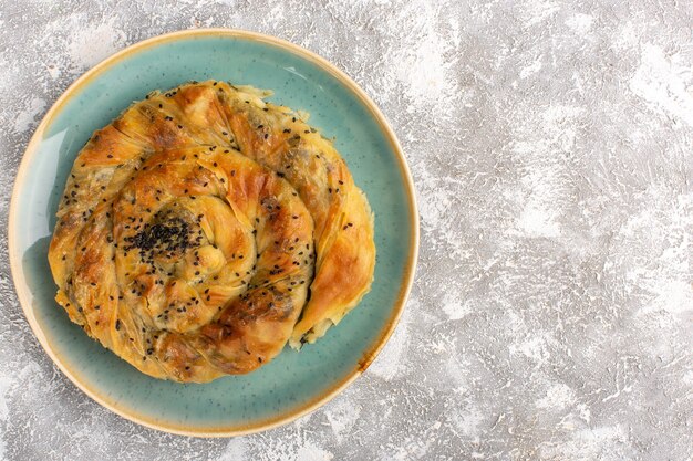 Top view of pastry with meat delicious dough meal inside plate on the light surface