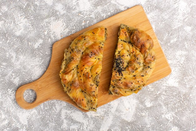 Top view of pastry with meat delicious dough meal sliced on white light surface