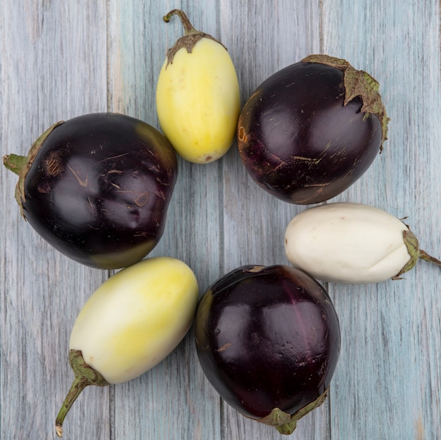 Top view of pattern of eggplants on wooden background