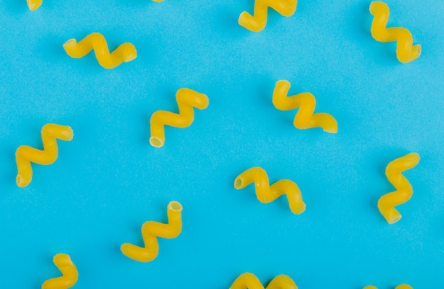 Free photo top view of pattern of fusilli pasta on blue surface