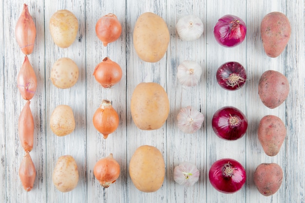 Free photo top view of pattern of vegetables as shallot onion potato garlic on wooden background