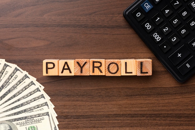 Top view payroll concept with cash and calculator