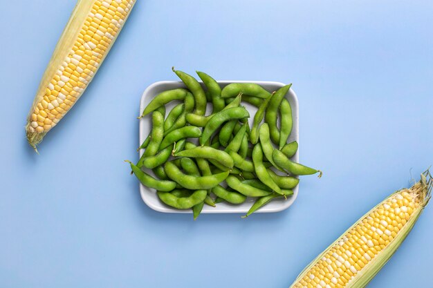 Top view pea pods on plate with corn