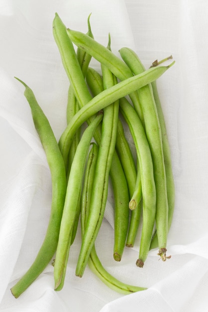 Top view pea pods on white cloth