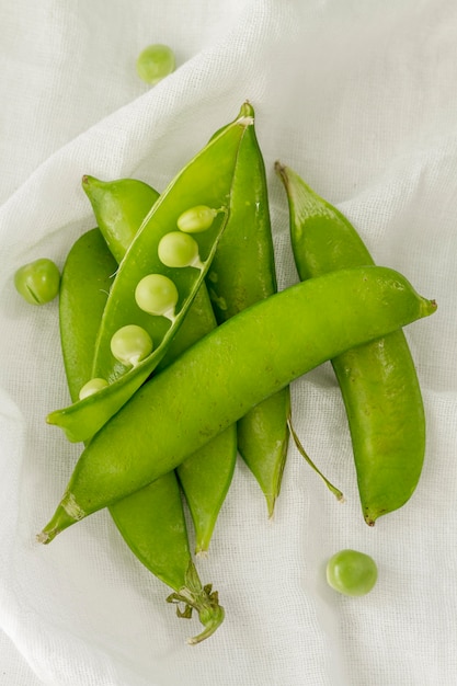 Top view pea pods on white cloth