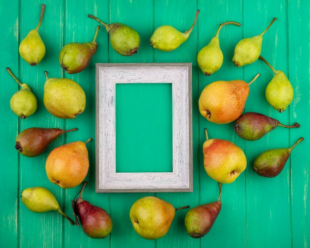 Top view of peaches around frame on green surface