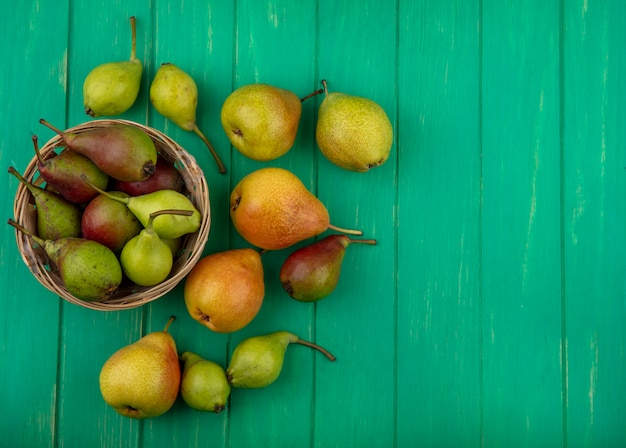 Free photo top view of peaches in basket and on green surface