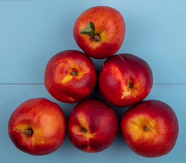 Top view of peaches on a light blue surface