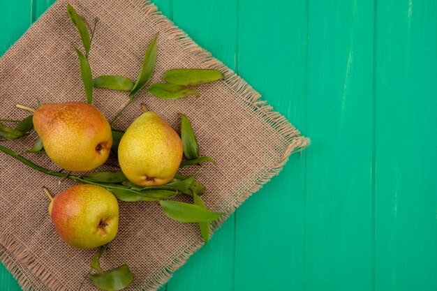 Top view of peaches on sackcloth and green surface