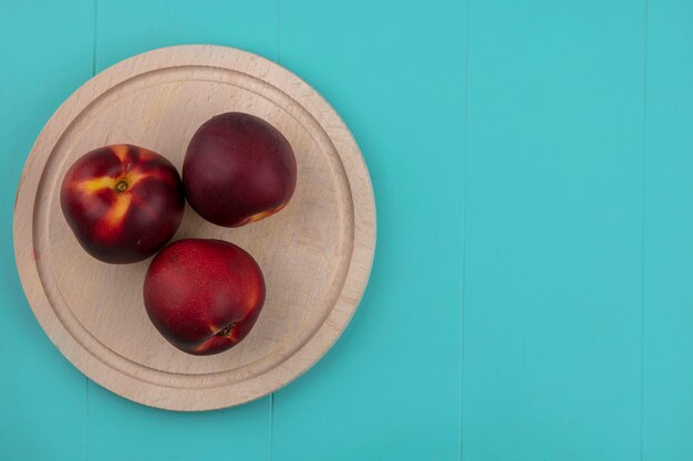 Top view of peaches on a stand on a blue surface