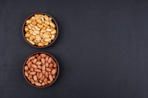 Top view peanuts in bowl on dark  with copy space