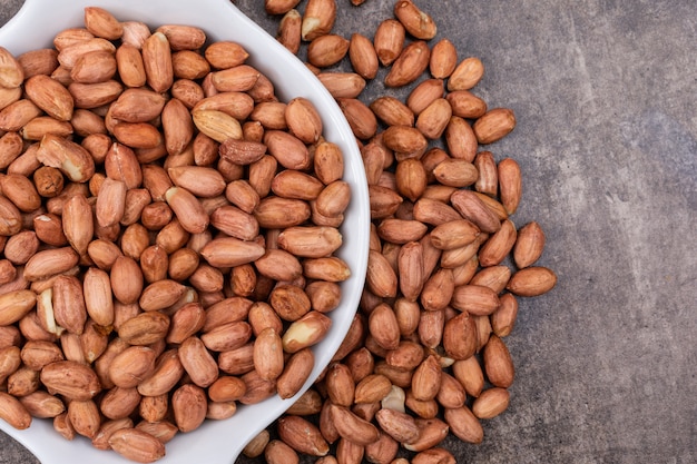 Top view peanuts in bowl on stone  horizontal with copy space