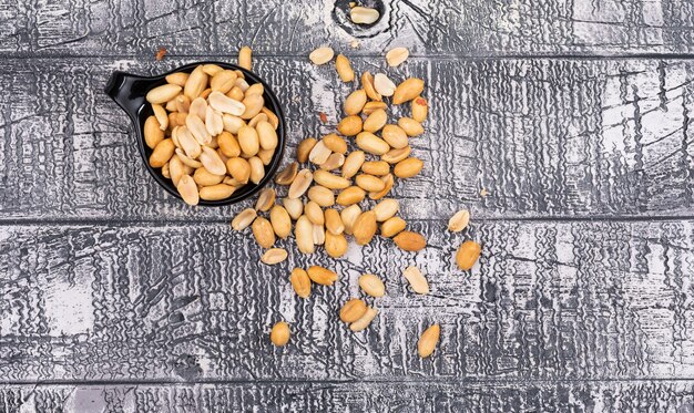 Top view peanuts in bowl on wooden gray  horizontal