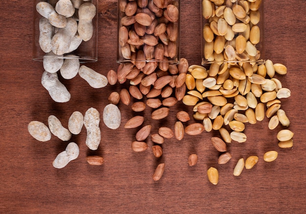 Top view peanuts in jars on wooden 