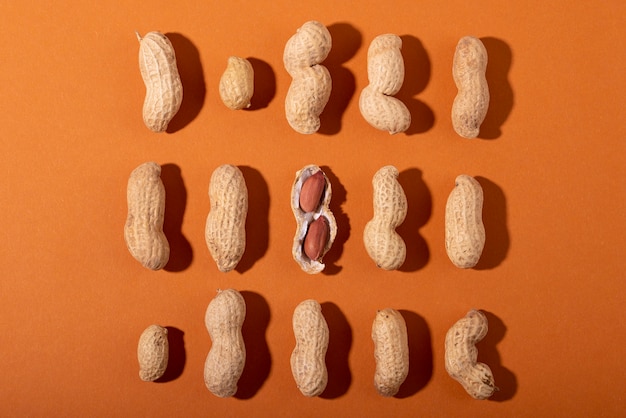 Free photo top view peanuts on orange background