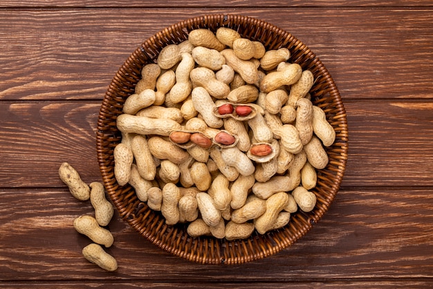 Top view peanuts in shell in a basket on a wooden table