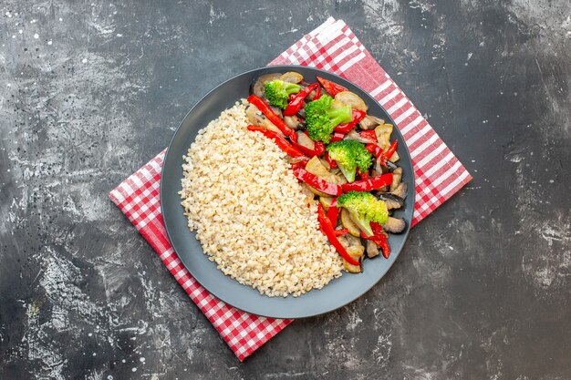 Top view pearl barley with tasty cooked vegetables on a grey table