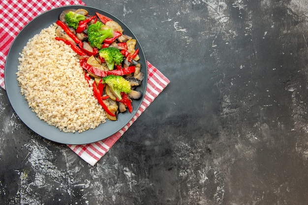 Orzo perlato vista dall'alto con gustose verdure cotte sul tavolo grigio