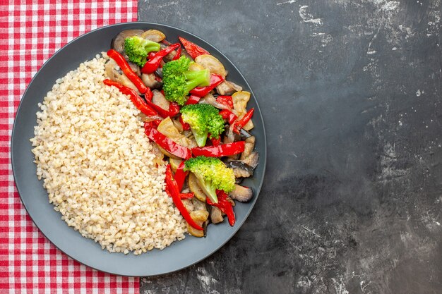 Top view pearl barley with tasty cooked vegetables on grey table