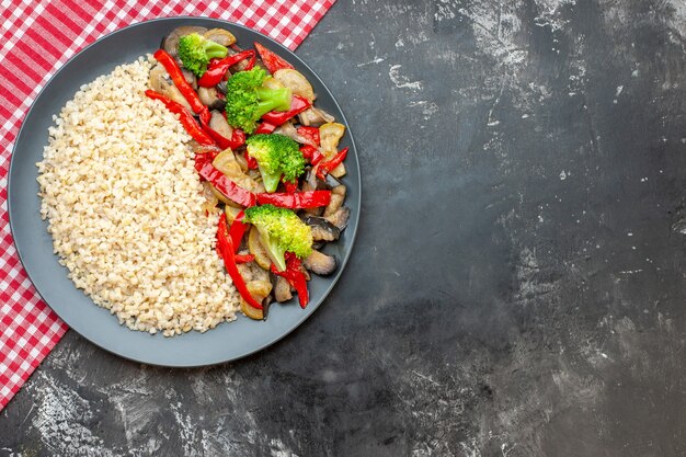 Top view pearl barley with tasty cooked vegetables on grey table