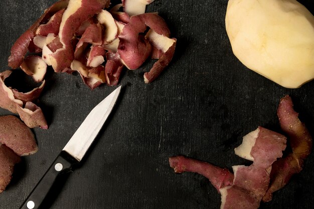 Top view of peeled potato with knife