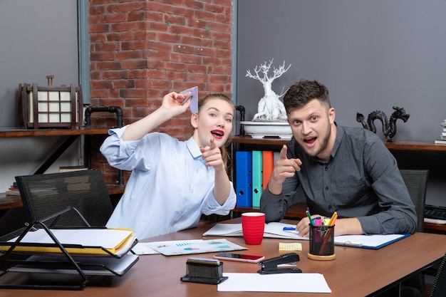 Free photo top view of pencil pushers concentrated on something with surprised facial expression in the office