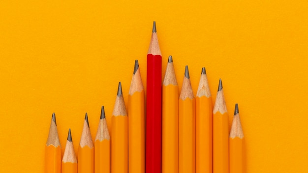Вид сверху карандаши на оранжевом фоне