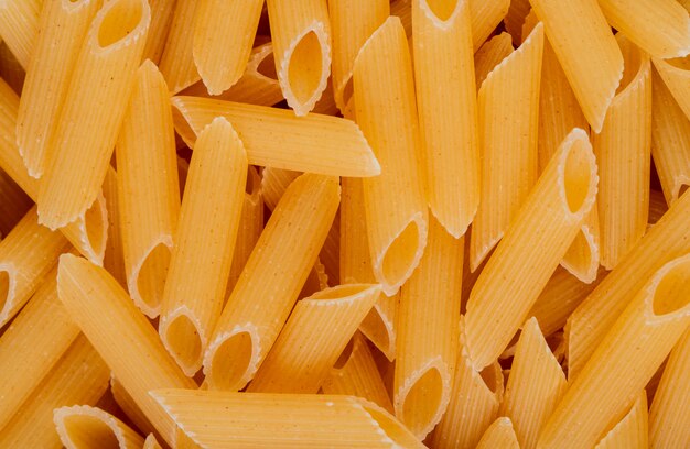 Top view of penne pasta background