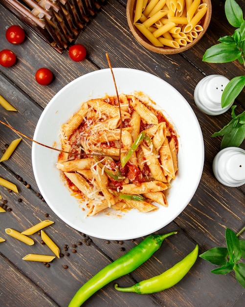 Top view of penne pasta with tomato sauce and bell pepper