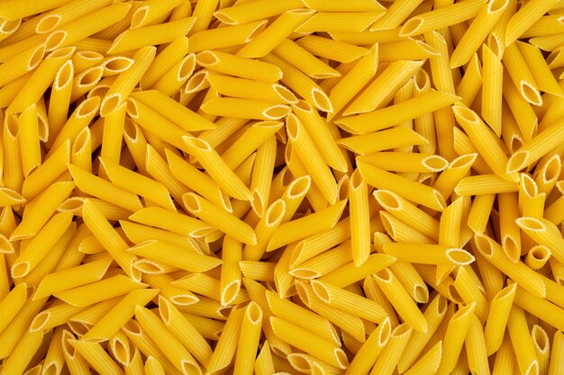 Top view of penne rigate pasta background