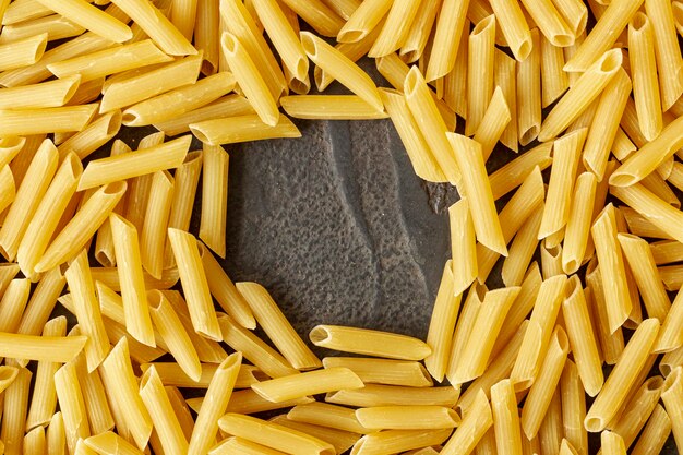 Top view of penne rigatte pasta on plain background