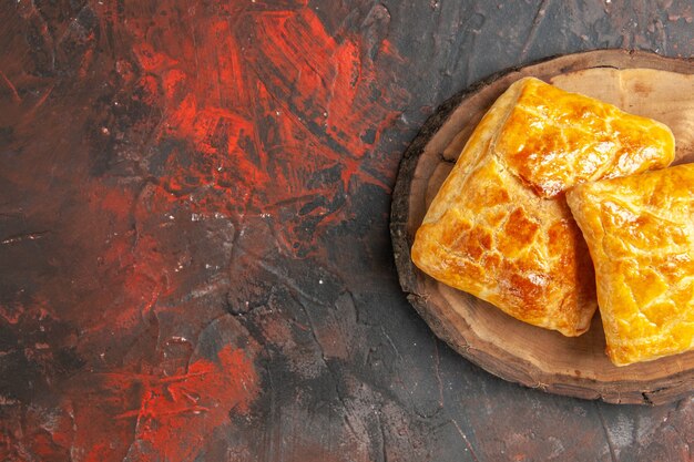 Top view of penovani khachapuri on wood board on dark red surface