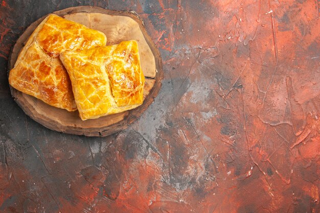 Top view of penovani khachapuri on wood board on dark red surface