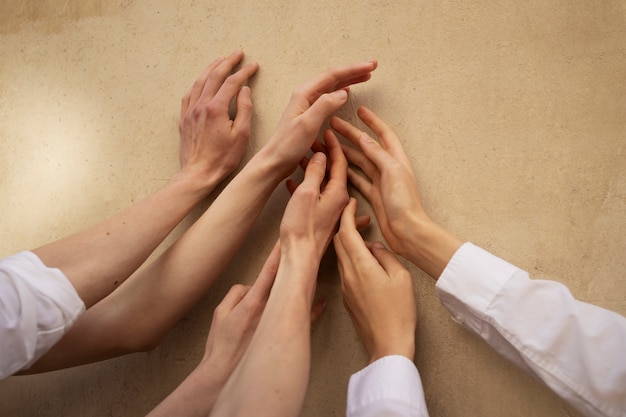 Free photo top view people putting hands together