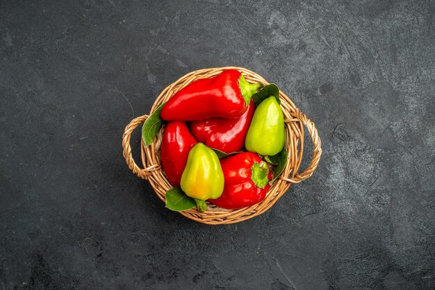 Top view pepper basket with red and green types on dark background with free space