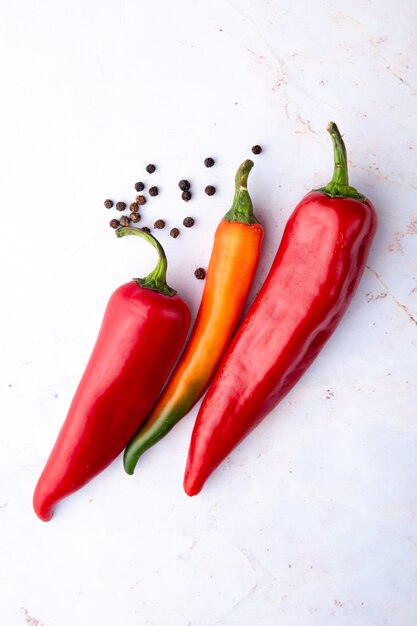Top view of peppers and pepper spice on right side and white background with copy space