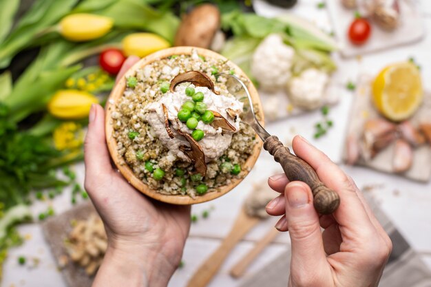 Top view of a person holding a bowl of delicious vegan salad