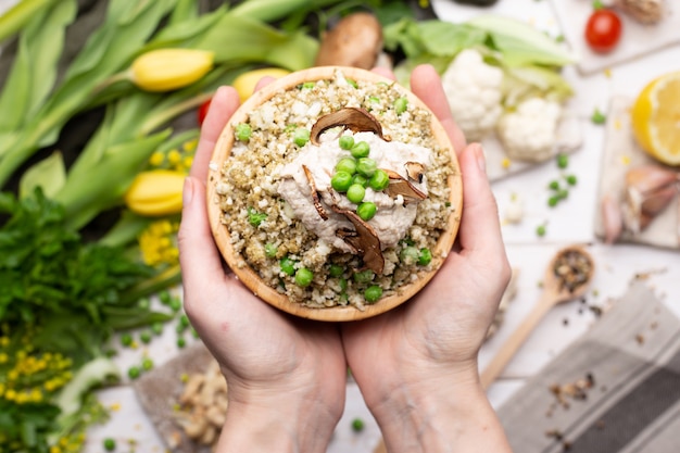 Top view of a person holding a bowl of delicious vegan salad