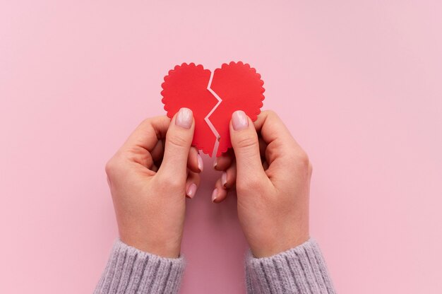 Top view of person holding broken heart