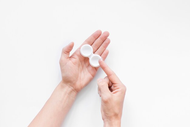 Top view person holding eye contacts on white background