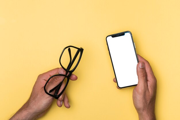 Top view person holding mockup smartphone