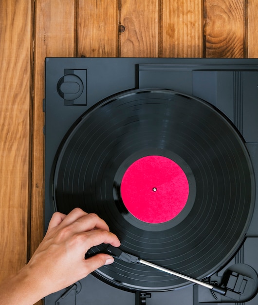 Top view person placing vinyl record in player