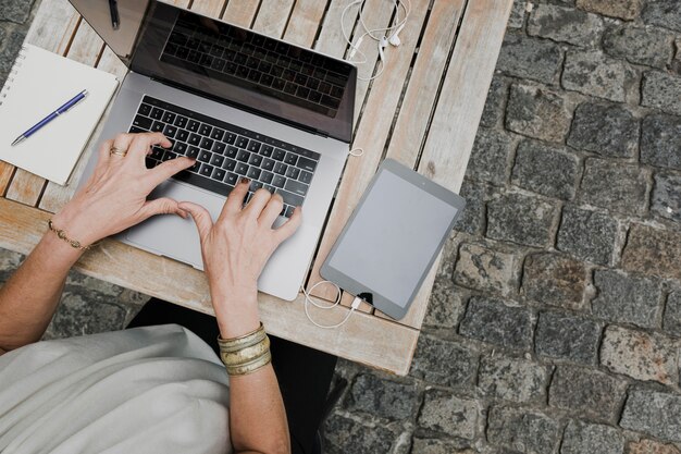 Top view of person typing on laptop outdoors