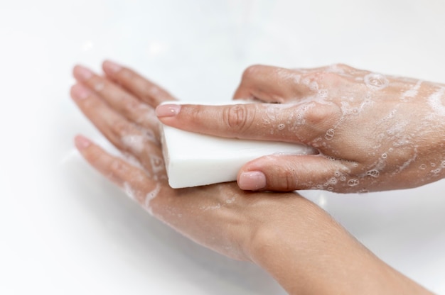 Free photo top view person washing hands with solid soap