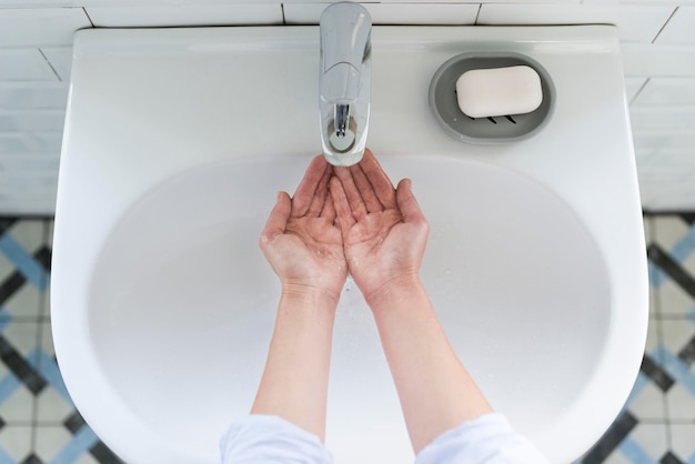 Free photo top view of person washing their hands at the sink