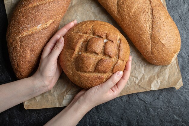 Top view photo of woman holding rye bread.