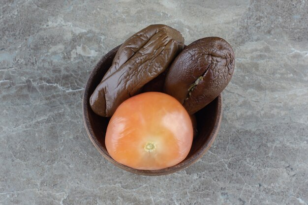 Foto gratuita vista dall'alto di melanzane sottaceto e pomodoro in una ciotola di legno.