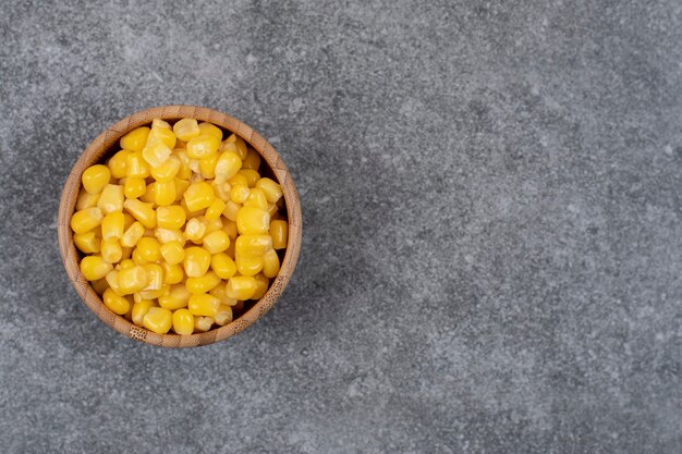 Top view of pickled sweet corn seeds in wooden bowl