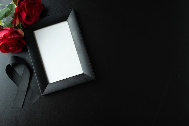 Free photo top view of picture frame with black bow on dark wall