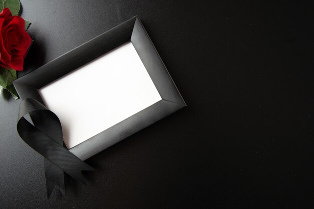 Top view of picture frame with black bow on dark wall